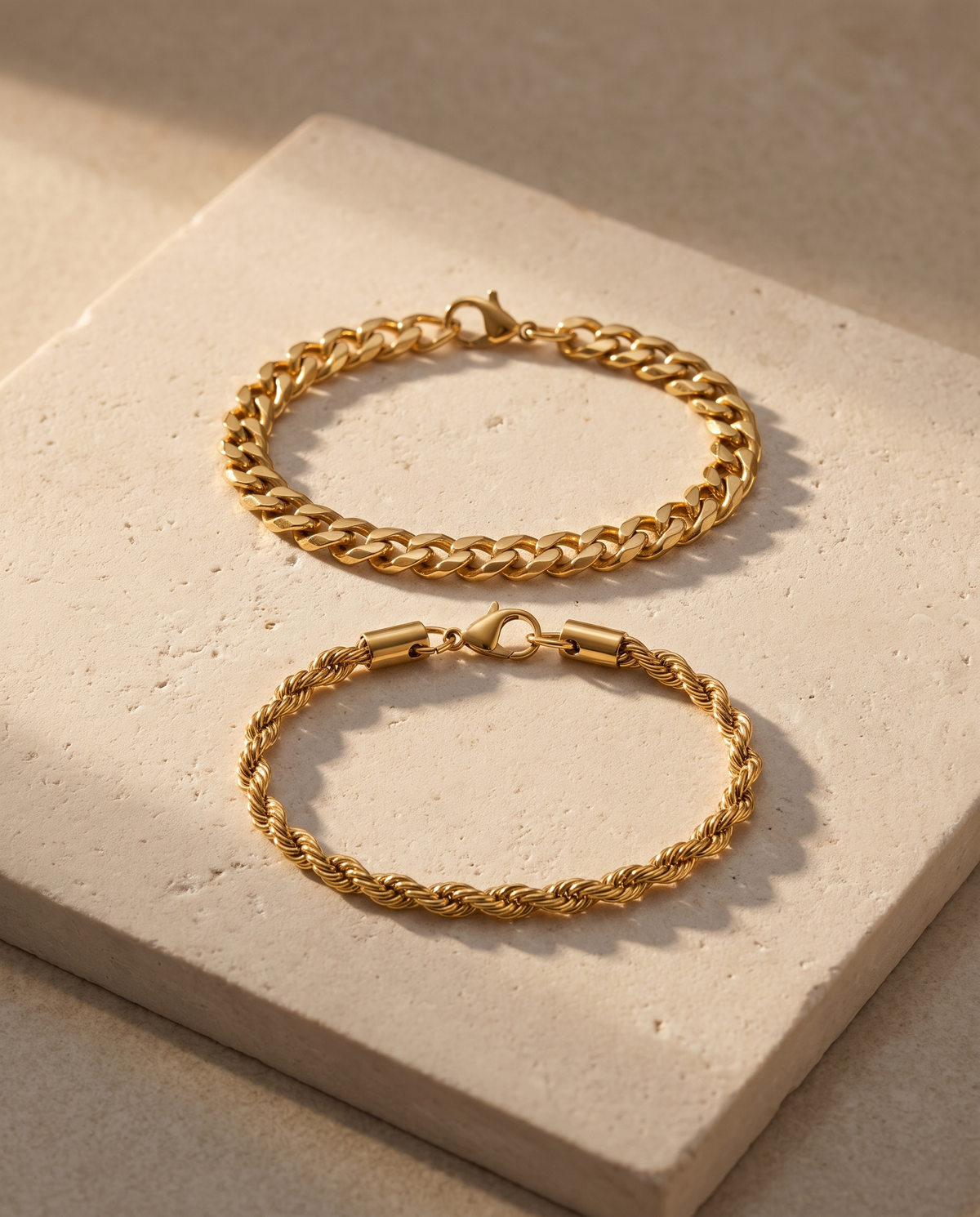 Sablon Stack in gold, both bracelets on a pale limestone slab