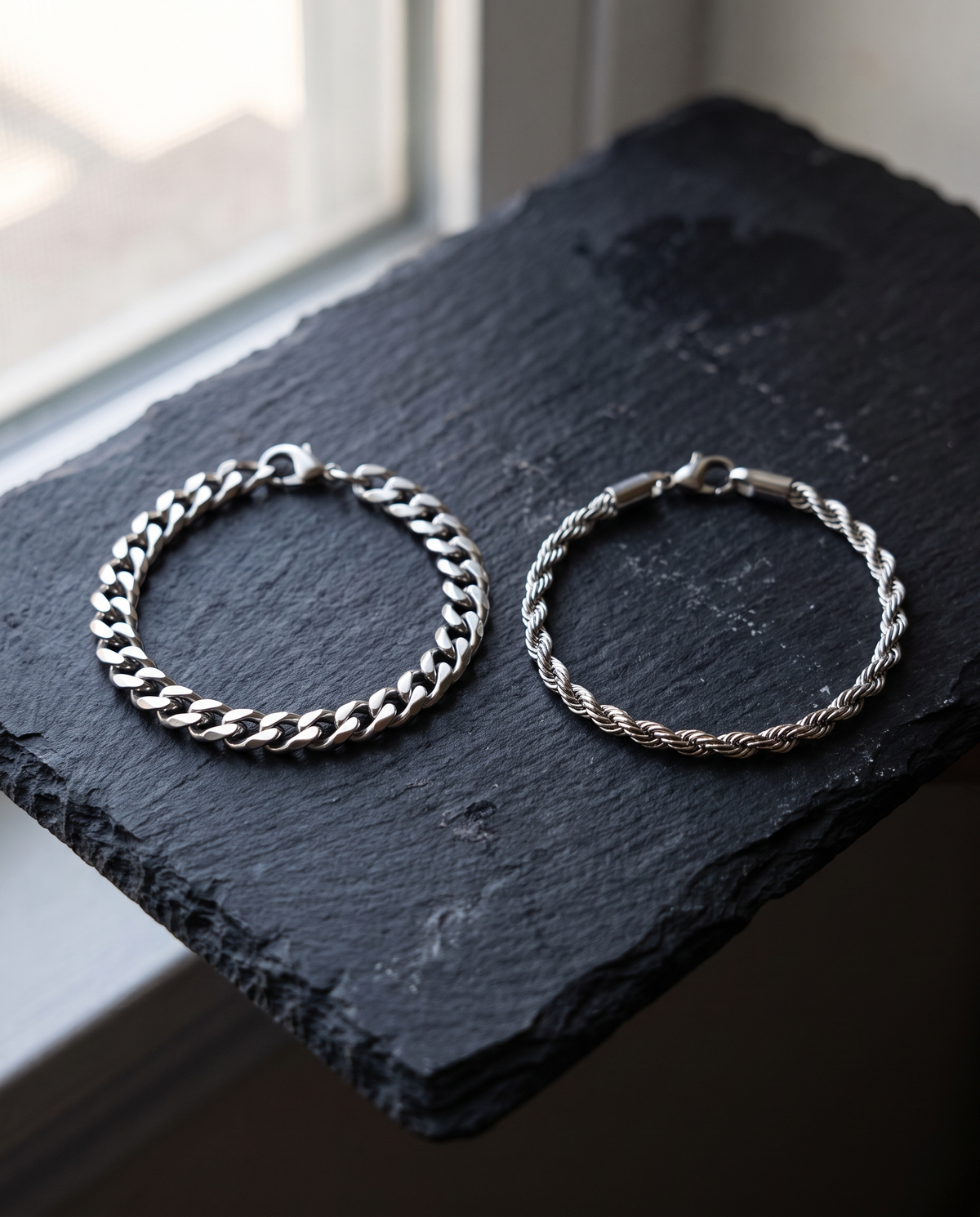 Sablon Stack in silver, both bracelets on dark slate by a window