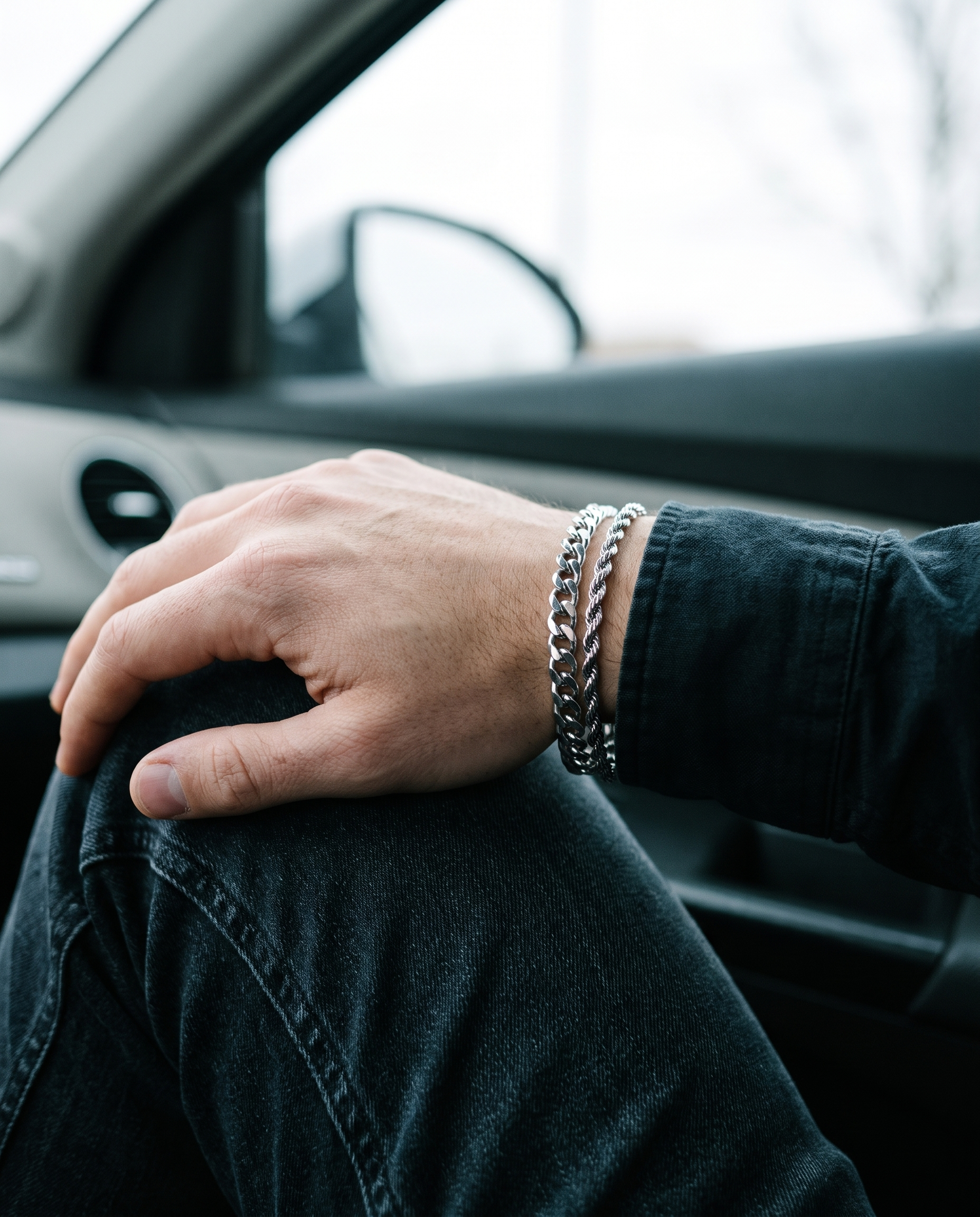 Sablon Stack in silver worn on the wrist, hand resting on a denim knee