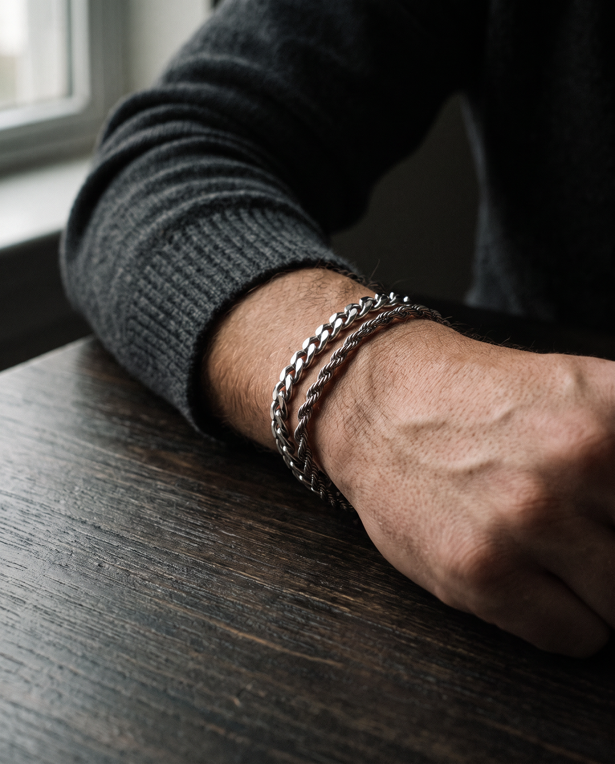Sablon Stack in silver worn on the wrist, forearm resting on a dark table