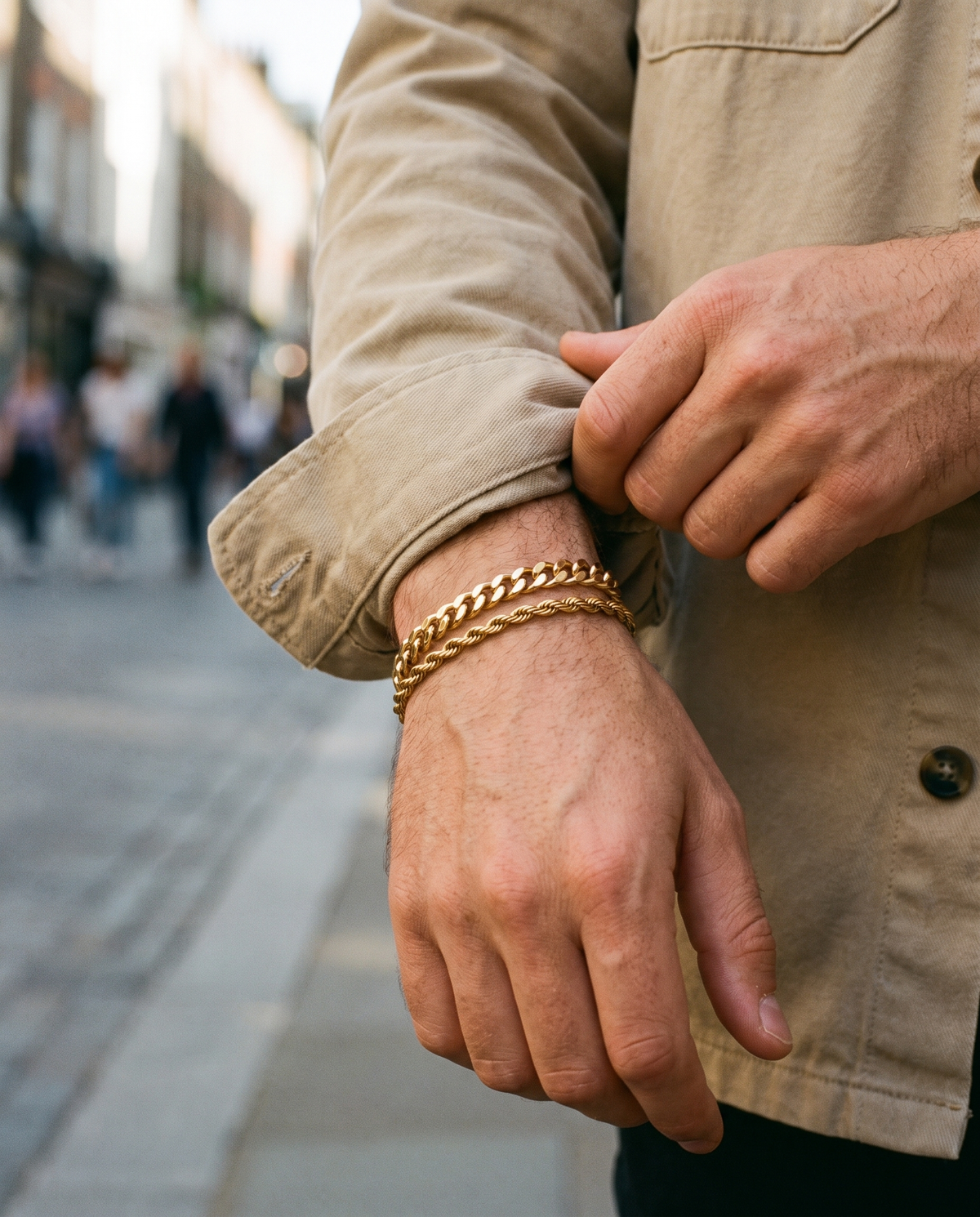 Sablon Stack in gold worn on the wrist, sleeve pushed back outdoors